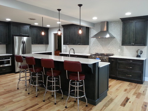 Cambria Torquay Countertop and Raised Breakfast Bar Island with Smoke Stain Maple Wood Cabinets, Natural Hickory Flooring and Stainless Steel Appliance and Stainless Steel Hood